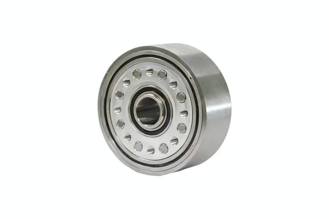 A shiny, cylindrical mechanical component featuring a central bearing assembly surrounded by evenly spaced circular indentations on a metallic face.