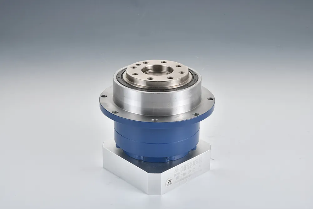 A blue and silver planetary gearbox on a silver base, featuring a circular flange with bolt holes and text "AH-090-10-K5-19" and "QC PASSED" on the base.