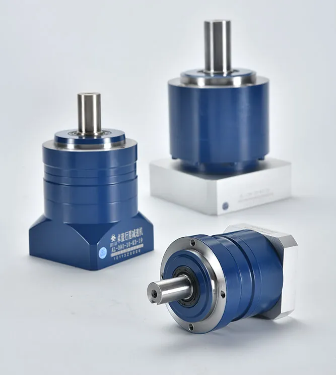 Three blue planetary gear reducers with silver output shafts are displayed on a white surface. One stands upright, while two lie horizontally. The label "卓蓝行星减速机 AL-090-10-K5-19" is visible on one.
