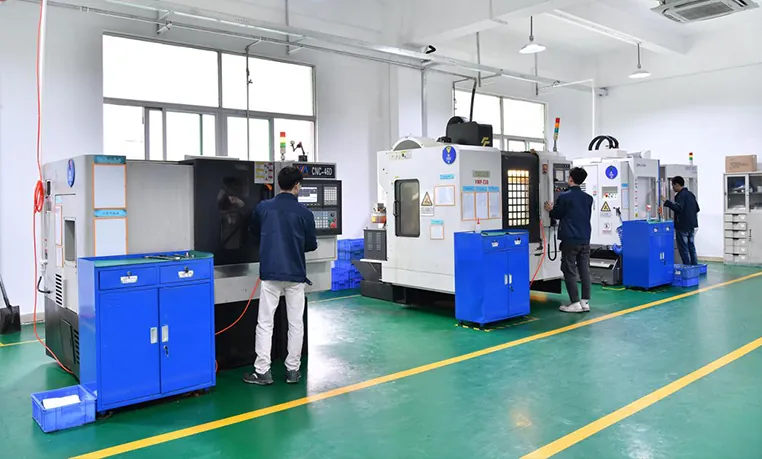 Technicians operate CNC machines along a production line in a manufacturing facility.