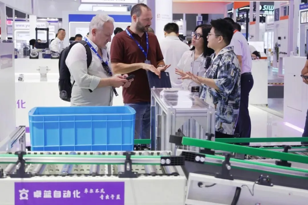 At an industrial automation exhibition, people are conversing near an electric drum.