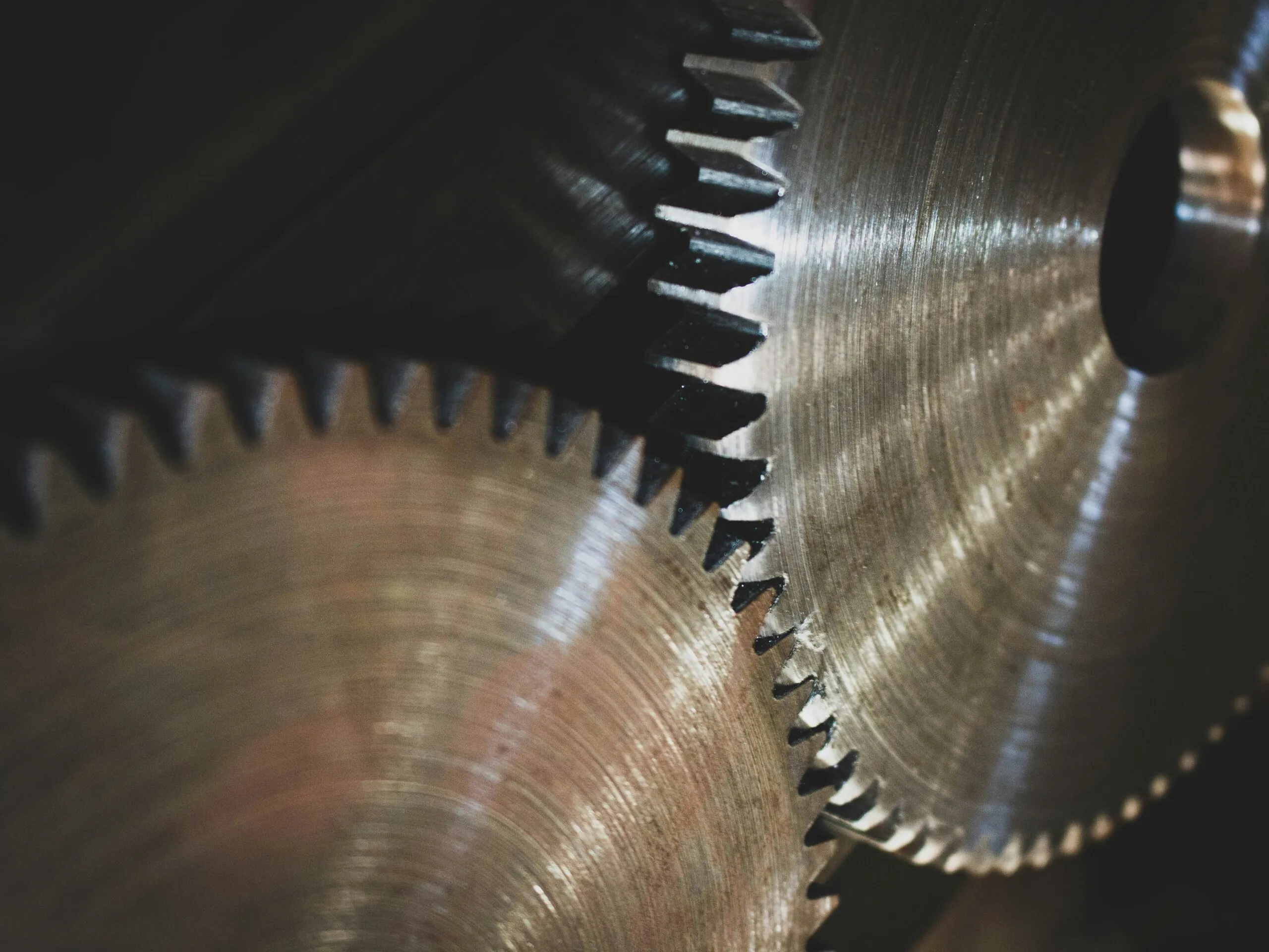 Close-up of interlocking metal gears with visible wear and machining marks, suggesting mechanical power transmission.