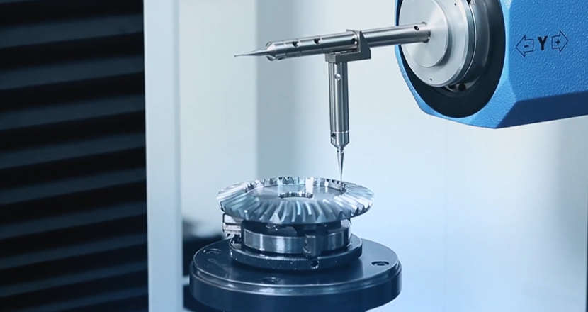 A coordinate measuring machine (CMM) probe touches a bevel gear mounted on a rotary table for precise measurement.