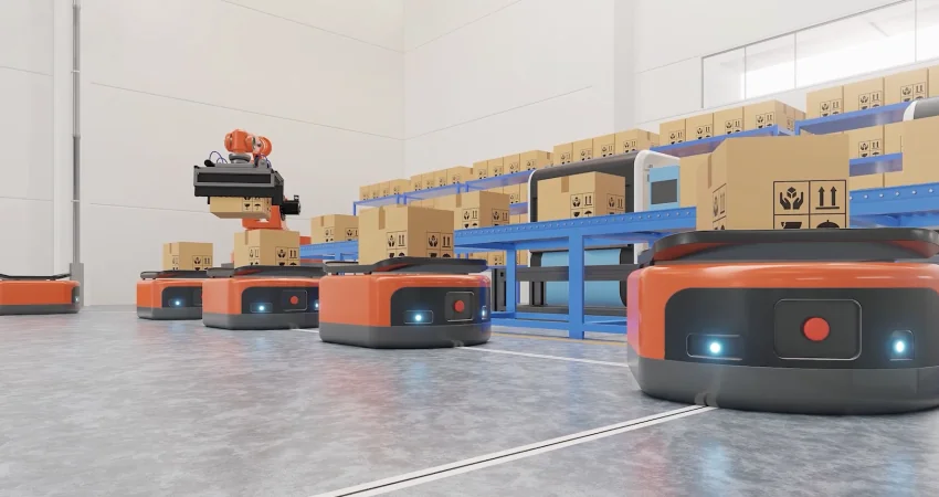 An automated warehouse scene with multiple orange and black autonomous mobile robots (AMRs) on a concrete floor. One AMR has a robotic arm stacking boxes, while others are positioned near blue conveyor belts filled with cardboard boxes.